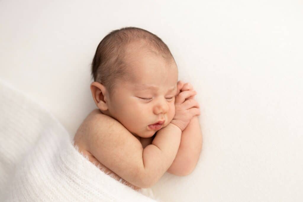 Newborn boy sleeping peacefully on white blanket in Melbourne Photography studio in Pakenham Victoria